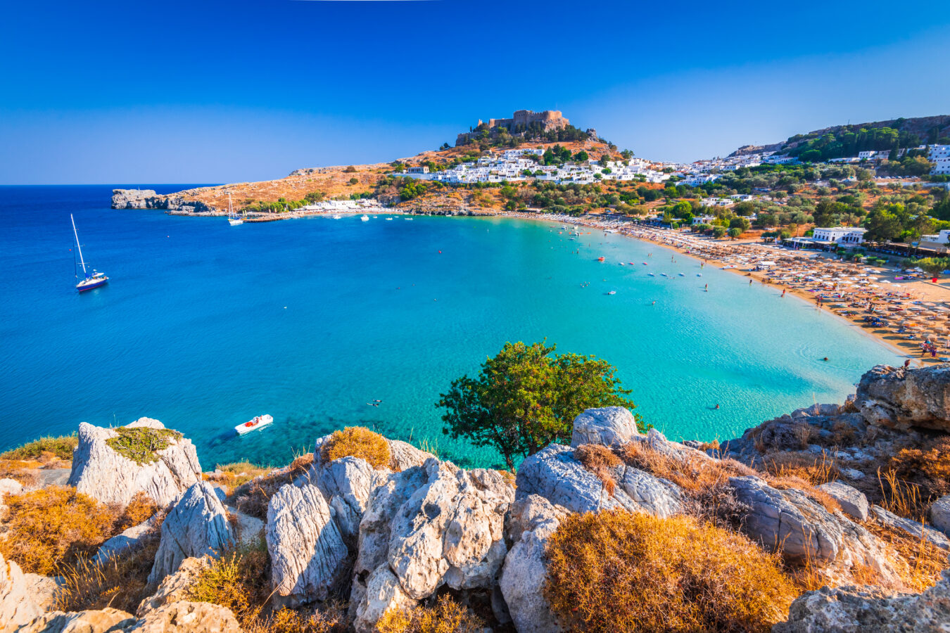View of Lindos beach and hilltop Acropolis, one of the most beautiful Rhodes villages